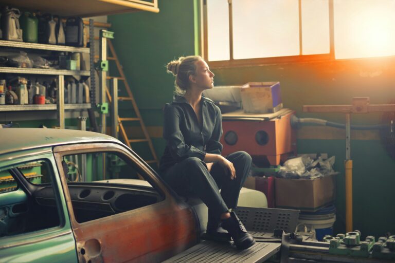 Woman sitting in garage at dusk
