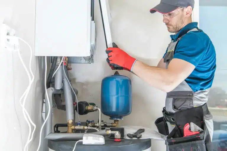 Dynamic Heating and Cooling technician installing a residential boiler system in Hamilton, ON.