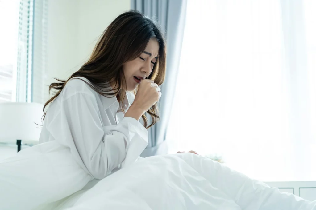 Woman coughing in bed