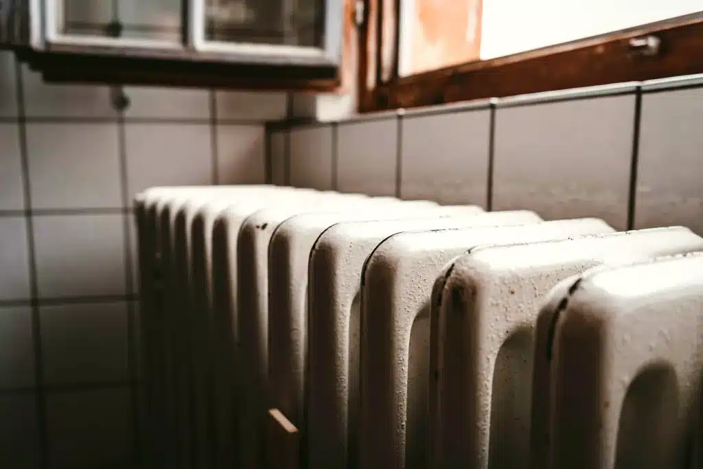 Cast-iron hot water radiator under a window in an older home