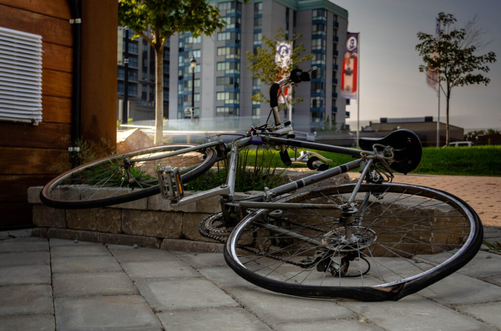 Bike laying on ground with city buildings in background - HVAC Orillia